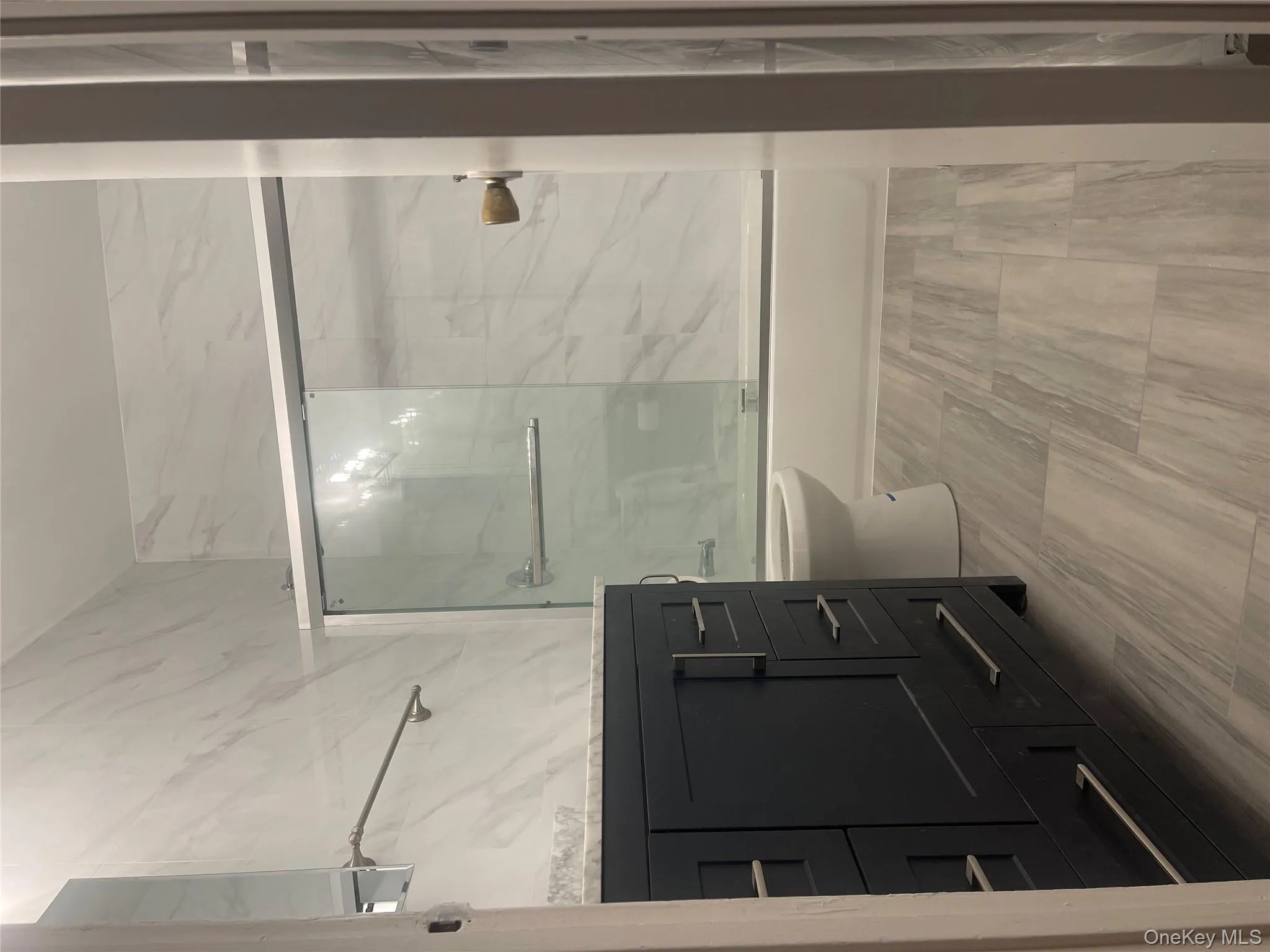 Full bathroom featuring vanity, combined bath / shower with glass door, and tile walls Full bathroom featuring vanity, combined bath / shower with glass door, and tile walls