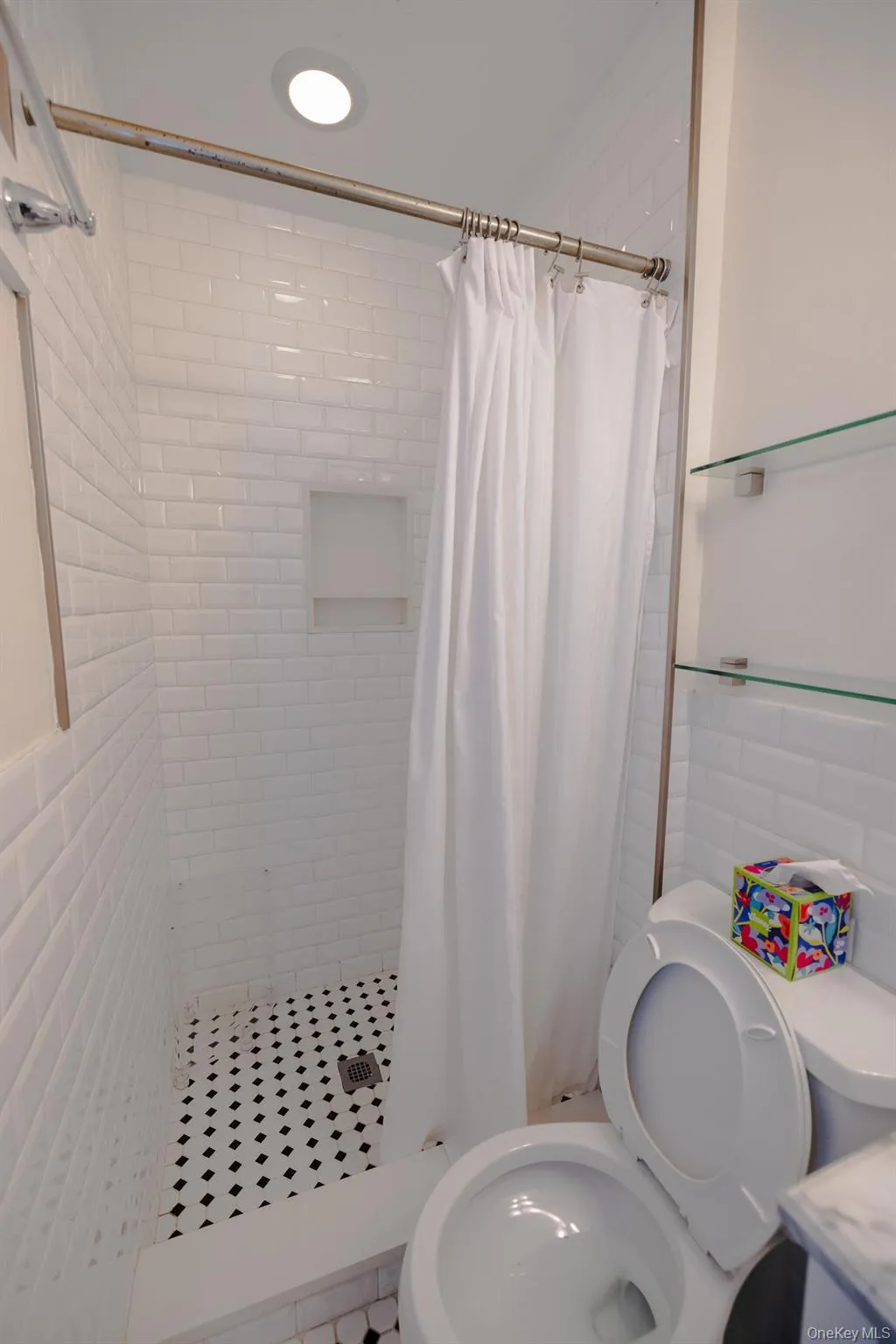 Bathroom featuring a stall shower, tile walls, wainscoting, and vanity Bathroom featuring a stall shower, tile walls, wainscoting, and vanity