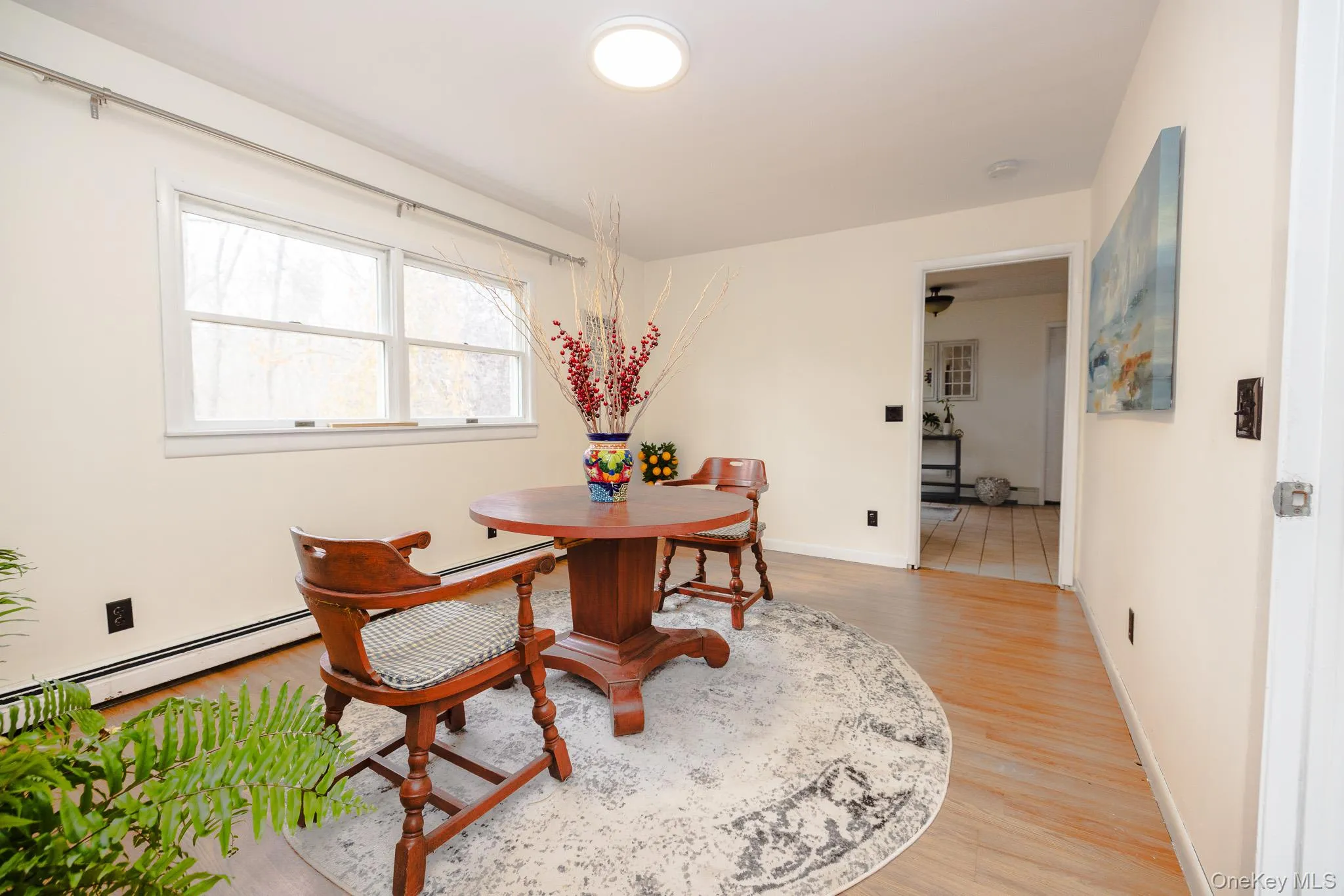 Dining area featuring light wood finished floors and a baseboard heating unit Dining area featuring light wood finished floors and a baseboard heating unit