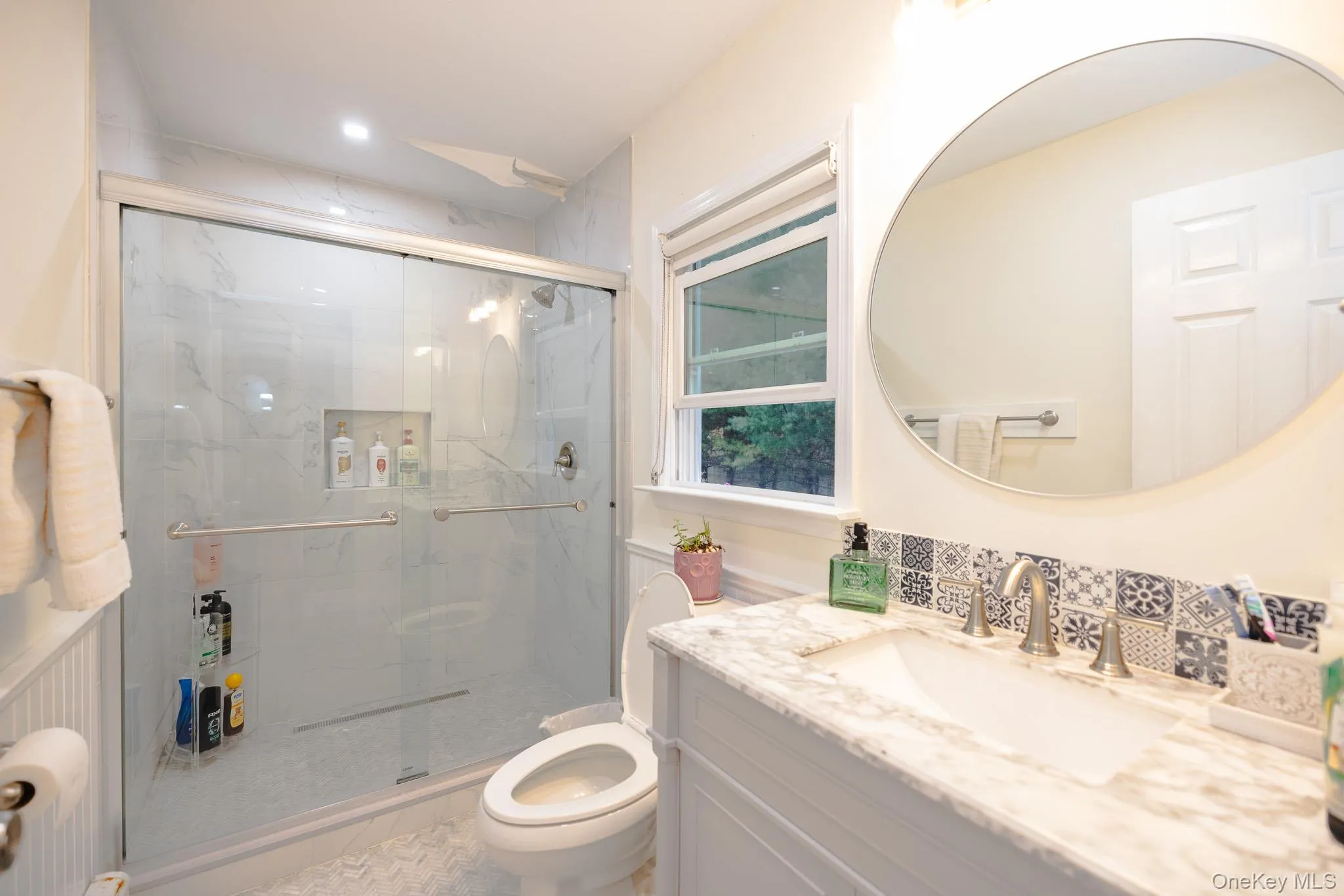 Bathroom with vanity and a marble finish shower Bathroom with vanity and a marble finish shower