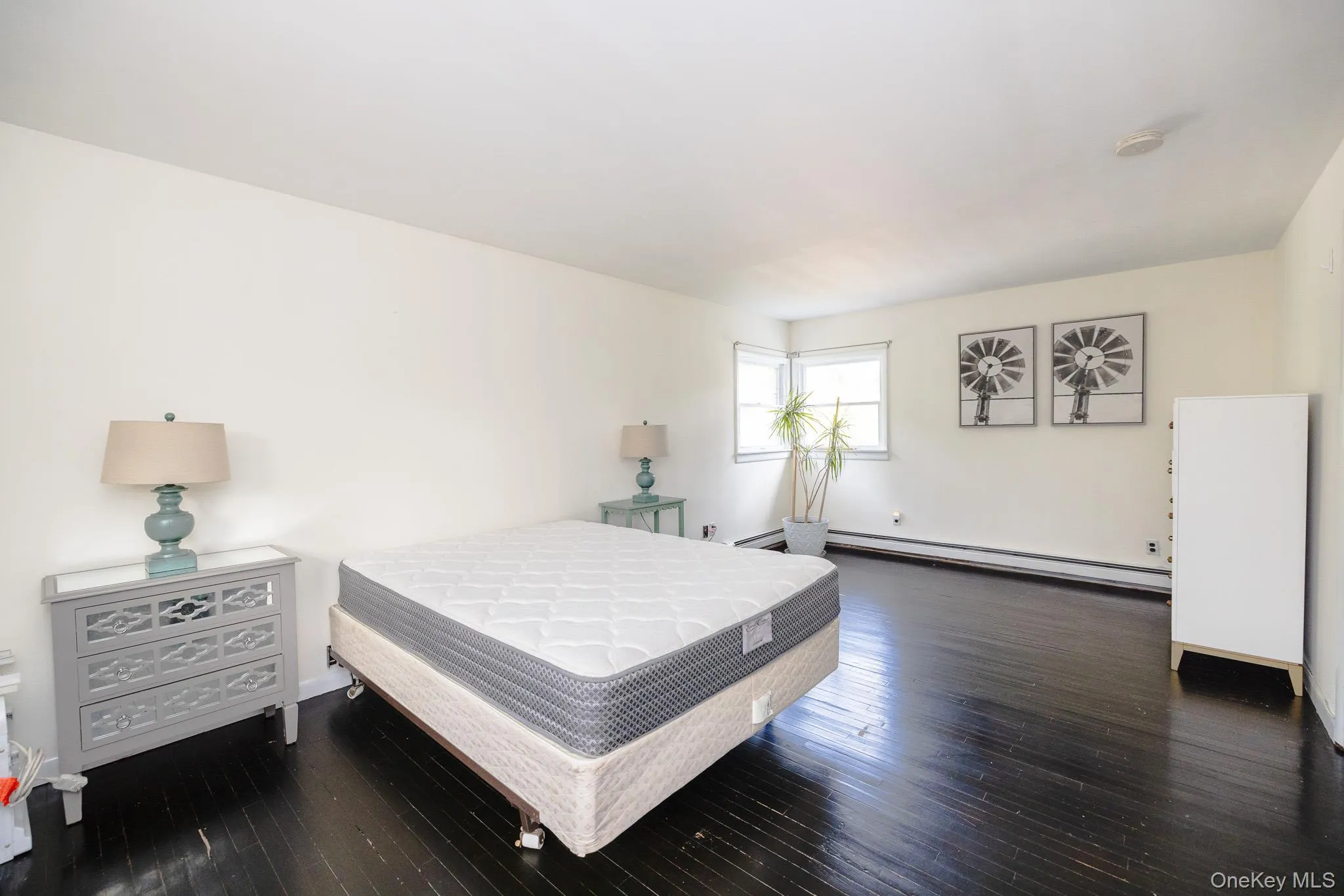 Bedroom with dark wood-type flooring and baseboard heating Bedroom with dark wood-type flooring and baseboard heating