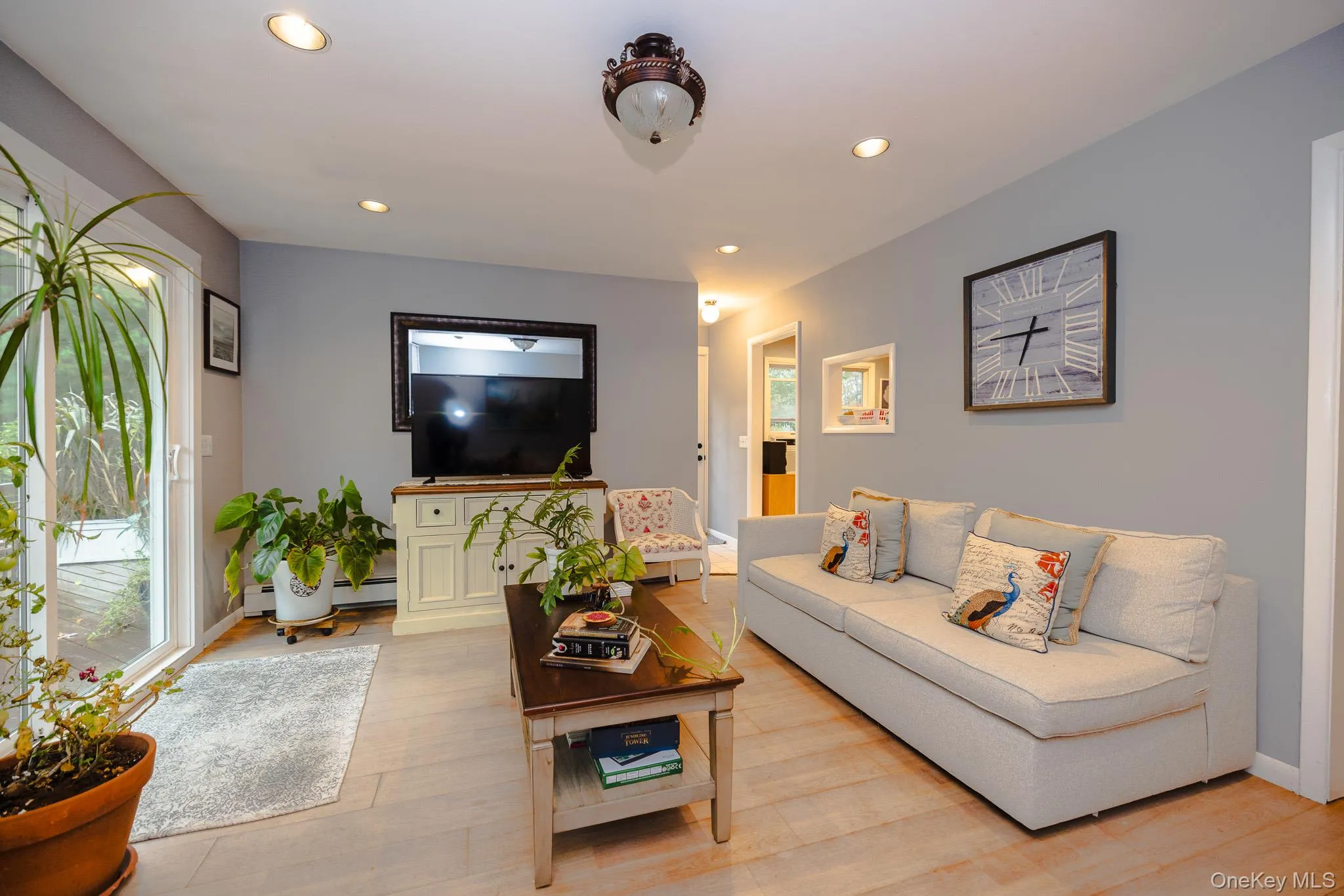 Living room featuring recessed lighting, wood finished floors, and healthy amount of natural light Living room featuring recessed lighting, wood finished floors, and healthy amount of natural light