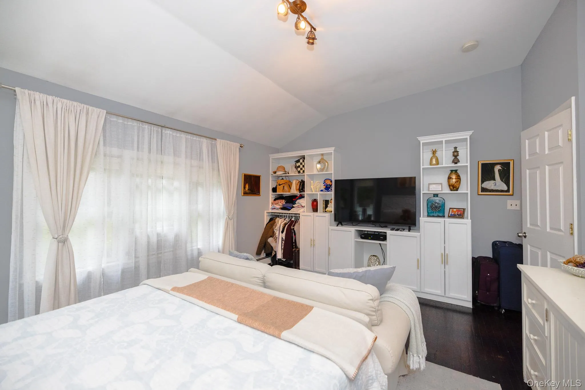 Bedroom featuring vaulted ceiling and dark wood-type flooring Bedroom featuring vaulted ceiling and dark wood-type flooring