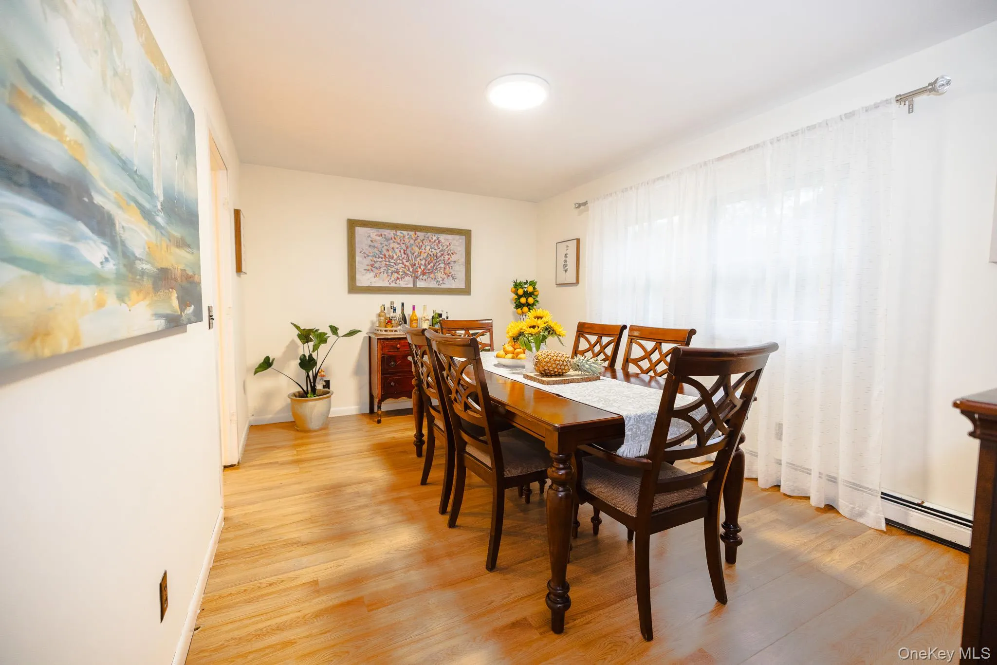 Dining room featuring light wood-style floors and baseboard heating Dining room featuring light wood-style floors and baseboard heating
