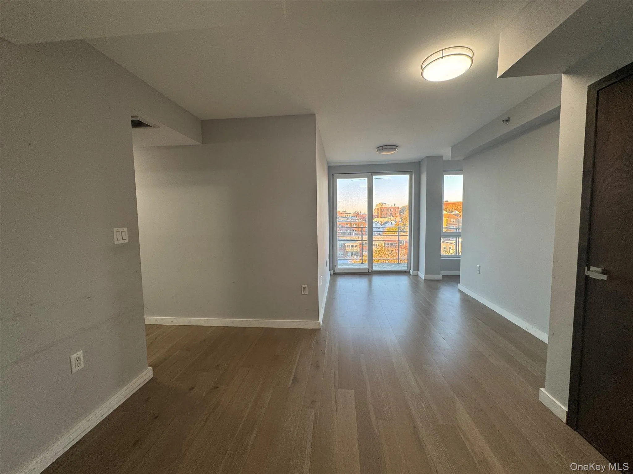 Spare room with dark wood-type flooring and baseboards Spare room with dark wood-type flooring and baseboards