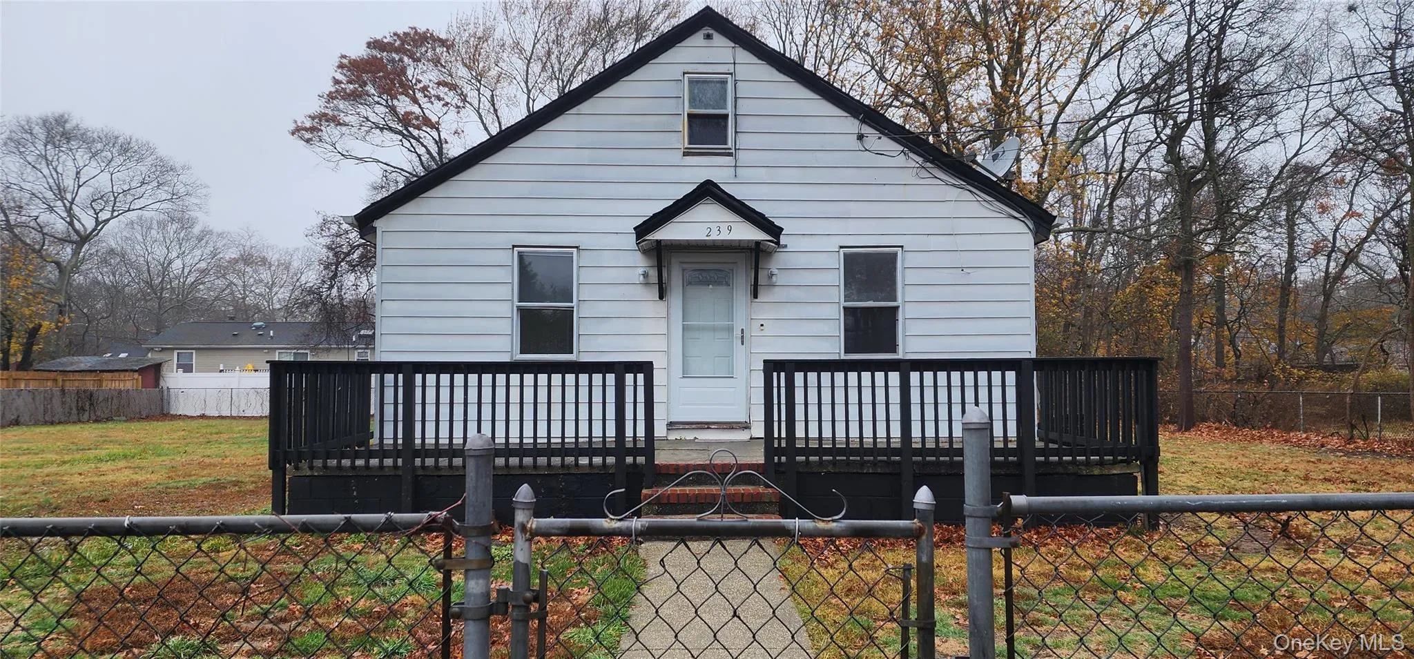 View of front facade with a fenced front yard, a deck, and a gate View of front facade with a fenced front yard, a deck, and a gate