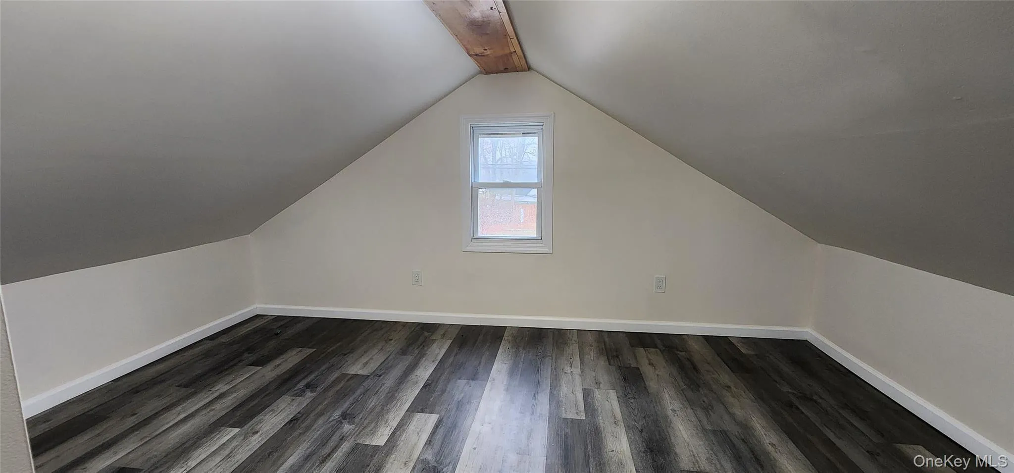 Bonus room with dark wood-style floors and baseboards Bonus room with dark wood-style floors and baseboards