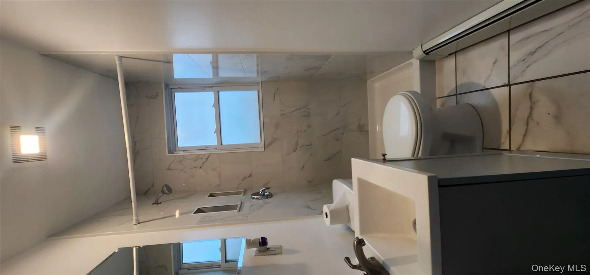 Full bathroom featuring a baseboard radiator, a marble finish shower, vanity, and healthy amount of natural light Full bathroom featuring a baseboard radiator, a marble finish shower, vanity, and healthy amount of natural light