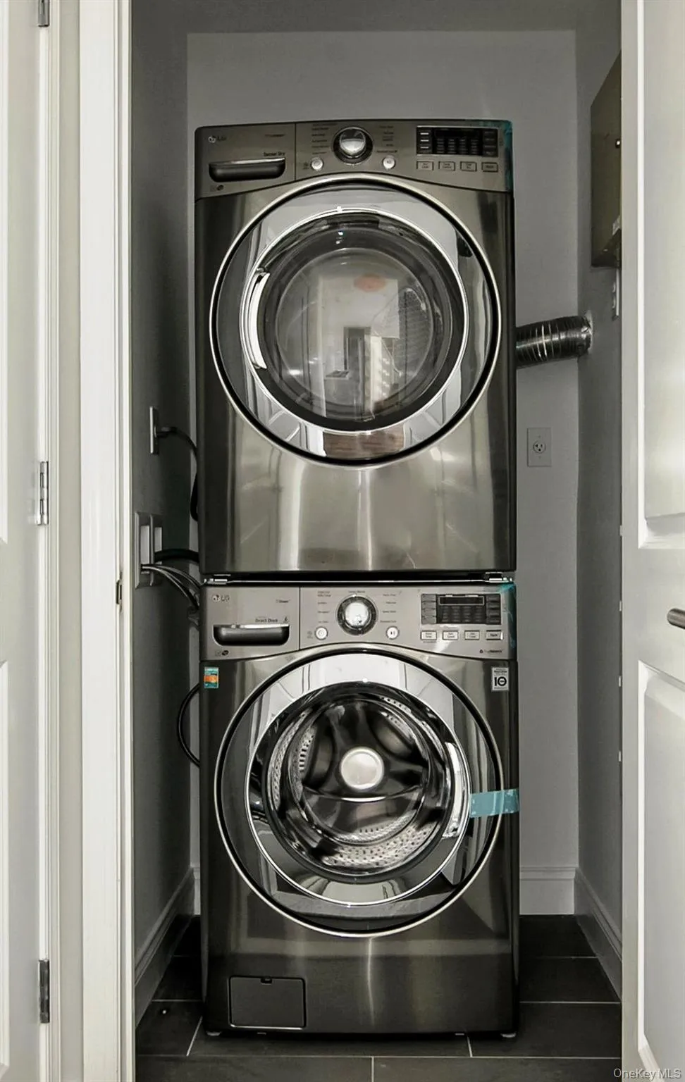 Laundry room featuring baseboards and stacked washer and clothes dryer Laundry room featuring baseboards and stacked washer and clothes dryer