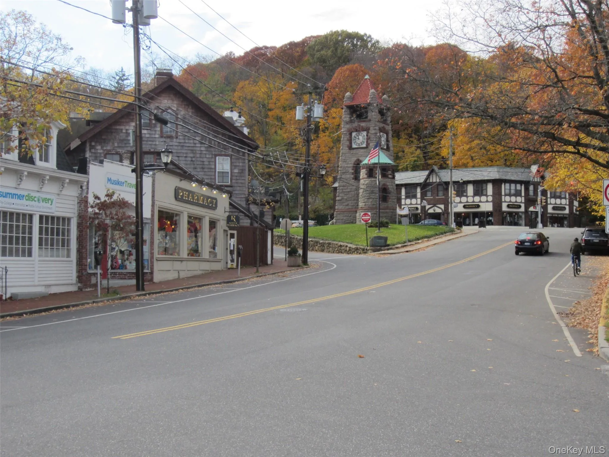 View of asphalt road with curbs, sidewalks, traffic signs, and street lighting View of asphalt road with curbs, sidewalks, traffic signs, and street lighting