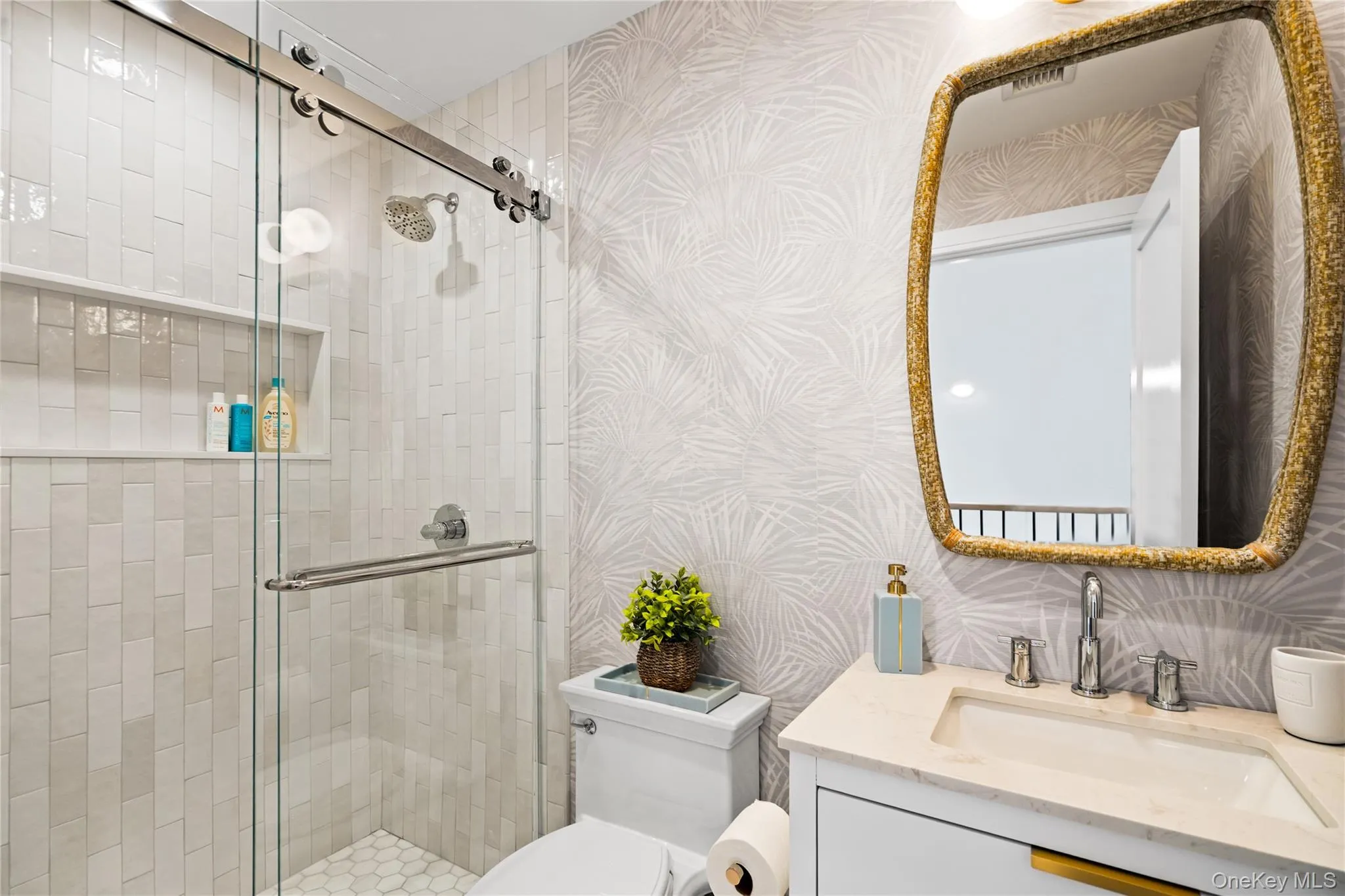 Bathroom featuring wallpapered walls, vanity, and a stall shower Bathroom featuring wallpapered walls, vanity, and a stall shower
