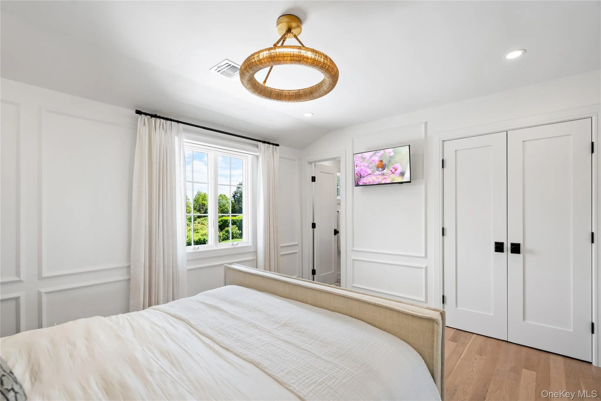 Bedroom with a decorative wall, wood finished floors, lofted ceiling, recessed lighting, and a closet Bedroom with a decorative wall, wood finished floors, lofted ceiling, recessed lighting, and a closet