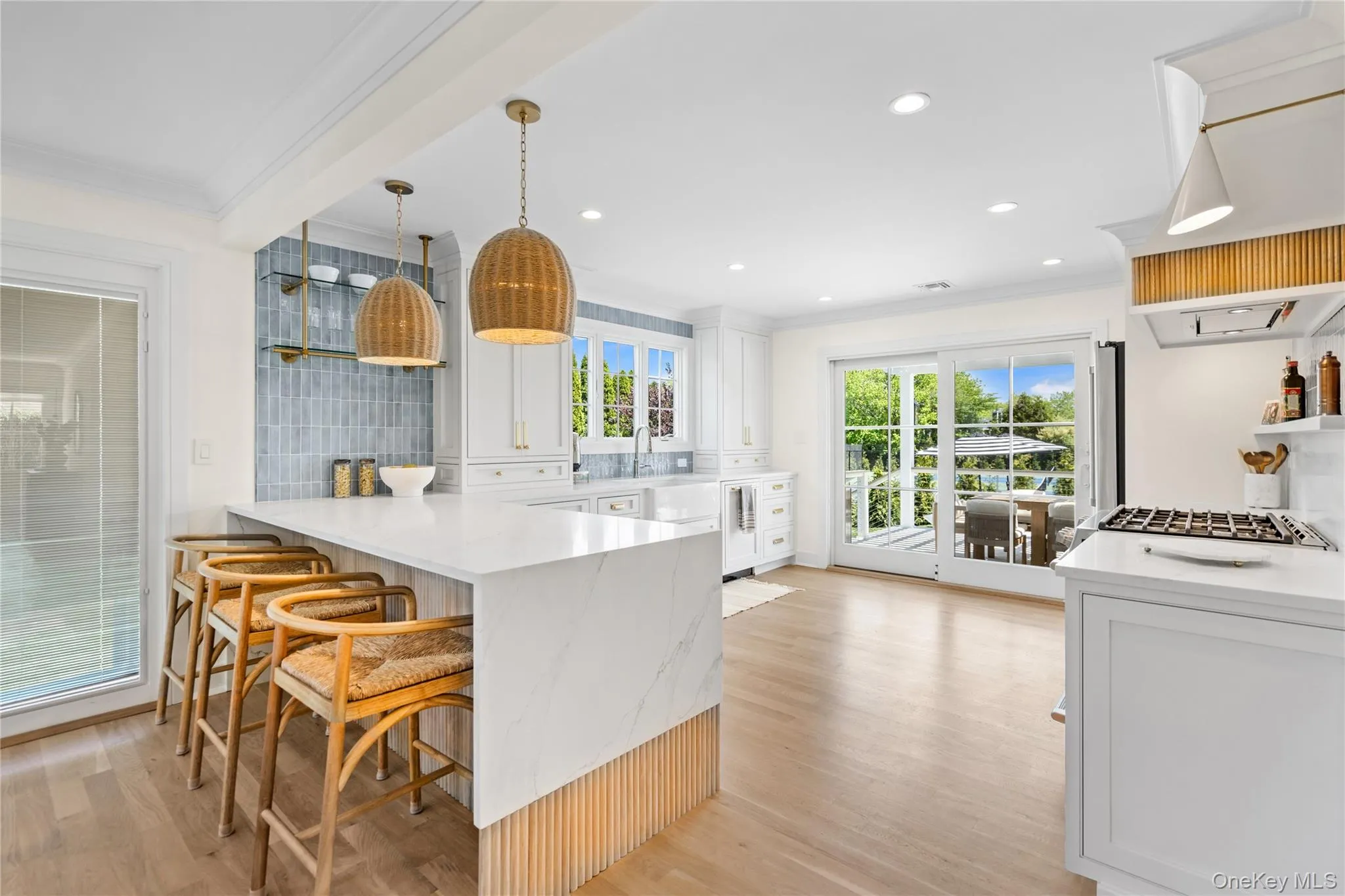 Kitchen with open shelves, a peninsula, light stone counters, ornamental molding, and a breakfast bar Kitchen with open shelves, a peninsula, light stone counters, ornamental molding, and a breakfast bar