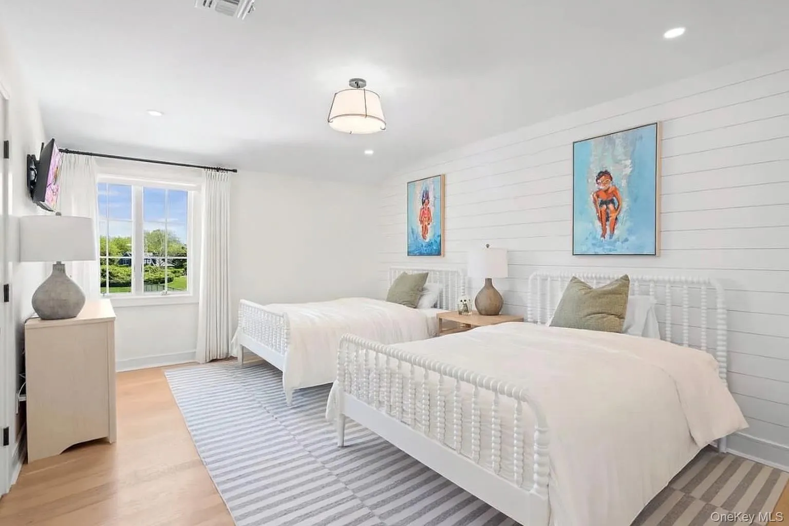 Bedroom with wood walls, light wood-style floors, and recessed lighting Bedroom with wood walls, light wood-style floors, and recessed lighting