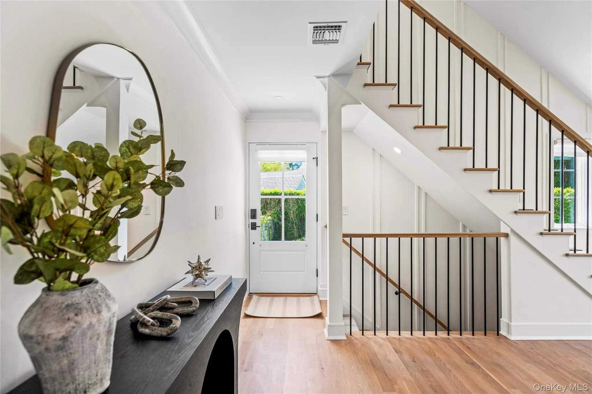 Entryway with ornamental molding, light wood finished floors, and stairs Entryway with ornamental molding, light wood finished floors, and stairs