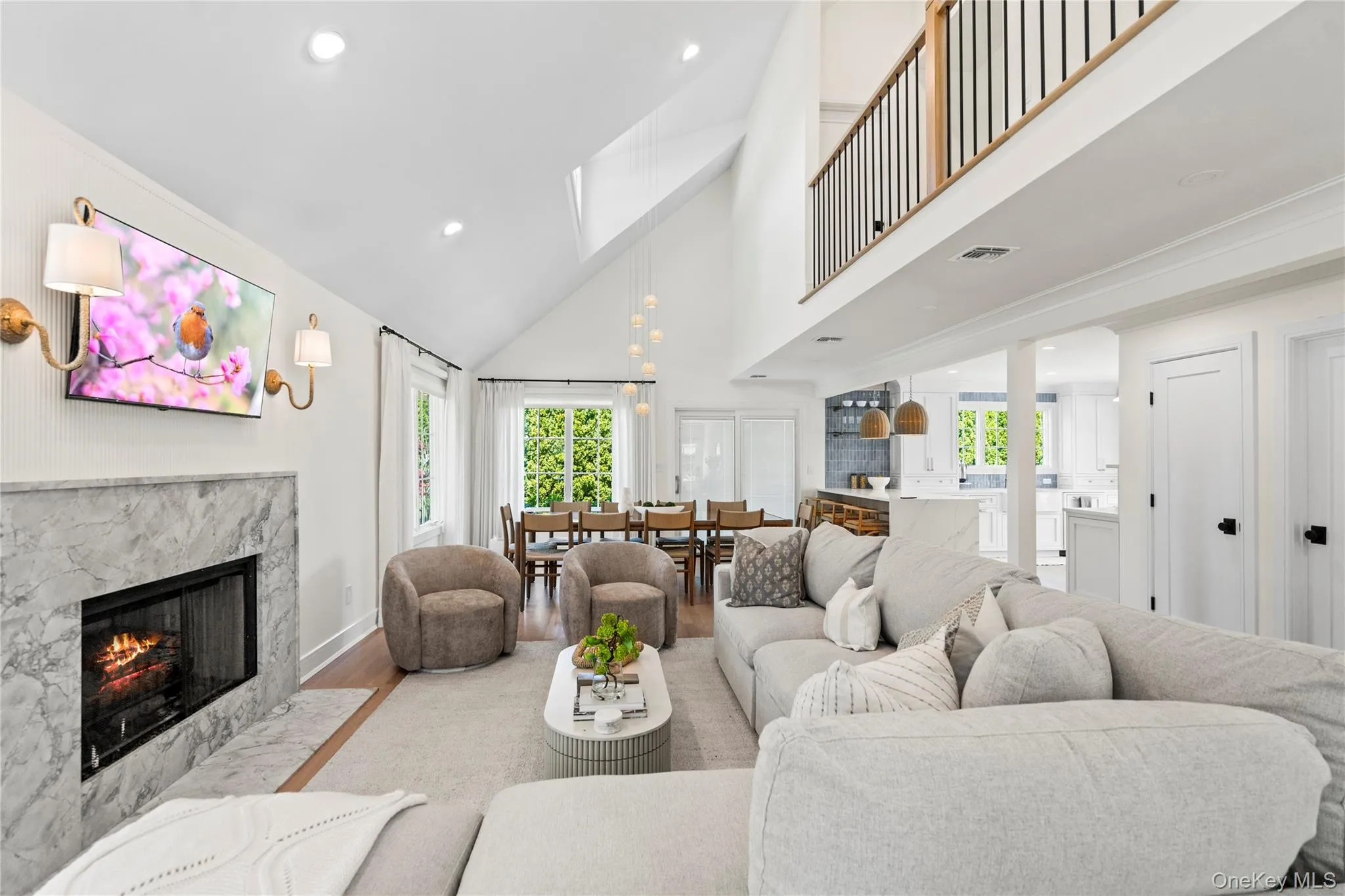 Living area featuring a premium fireplace, high vaulted ceiling, wood finished floors, and recessed lighting Living area featuring a premium fireplace, high vaulted ceiling, wood finished floors, and recessed lighting