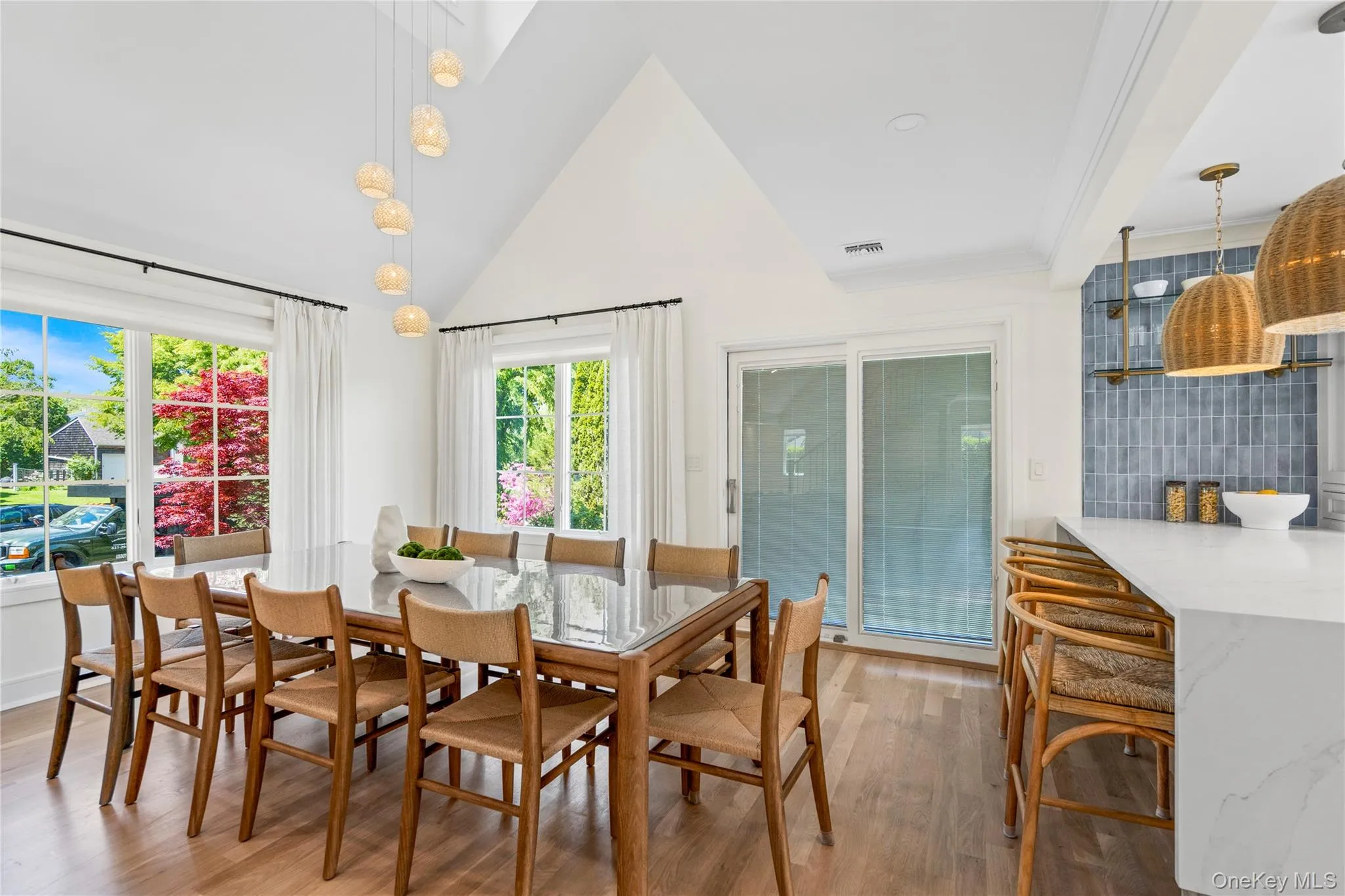 Dining area with high vaulted ceiling, light wood-style flooring, and plenty of natural light Dining area with high vaulted ceiling, light wood-style flooring, and plenty of natural light