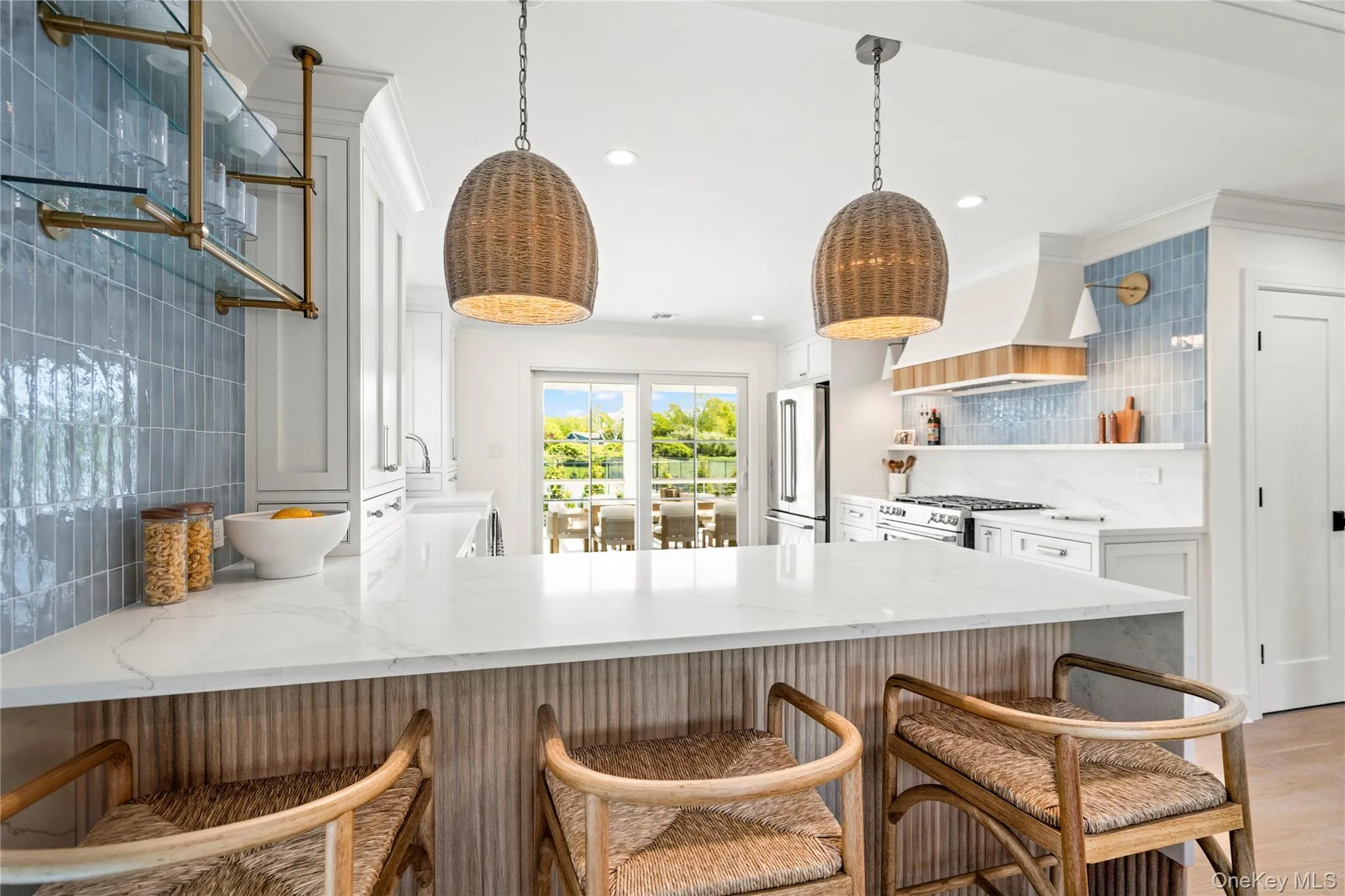 Kitchen with light stone countertops, a breakfast bar, open shelves, recessed lighting, and crown molding Kitchen with light stone countertops, a breakfast bar, open shelves, recessed lighting, and crown molding