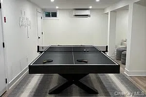 Rec room featuring an AC wall unit and recessed lighting Rec room featuring an AC wall unit and recessed lighting