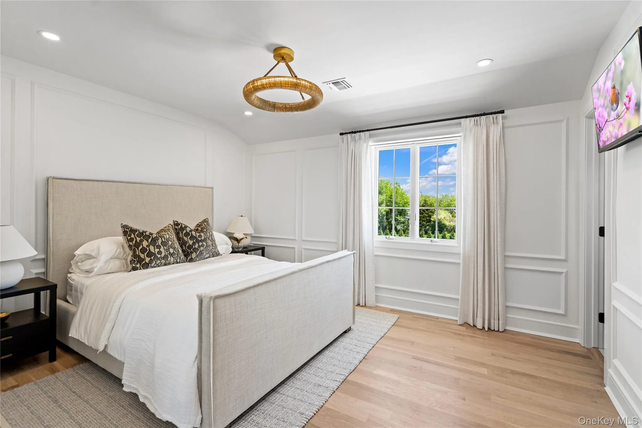 Bedroom featuring a decorative wall, light wood finished floors, and recessed lighting Bedroom featuring a decorative wall, light wood finished floors, and recessed lighting