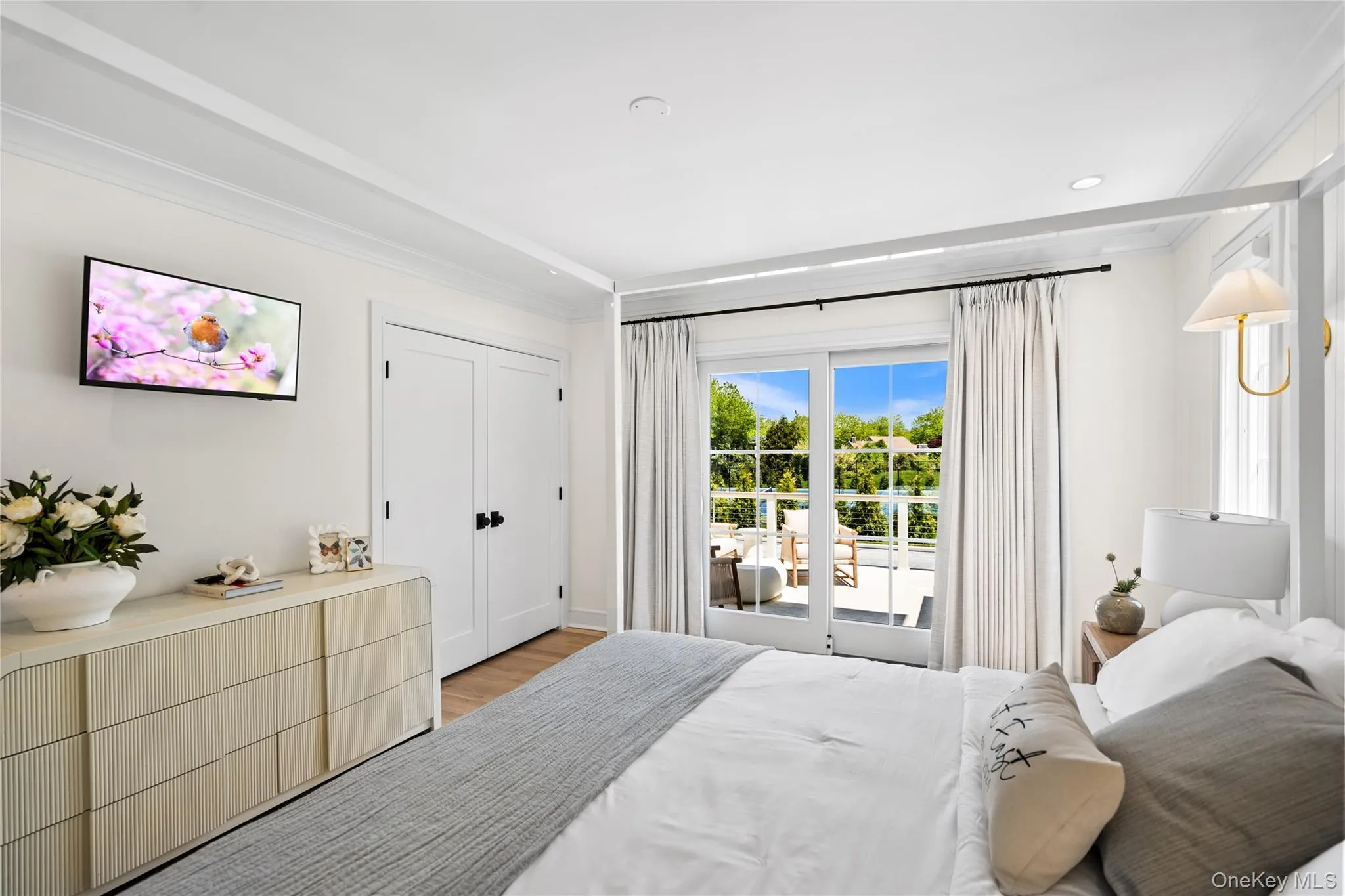 Bedroom with access to exterior, crown molding, a closet, and light wood-type flooring Bedroom with access to exterior, crown molding, a closet, and light wood-type flooring