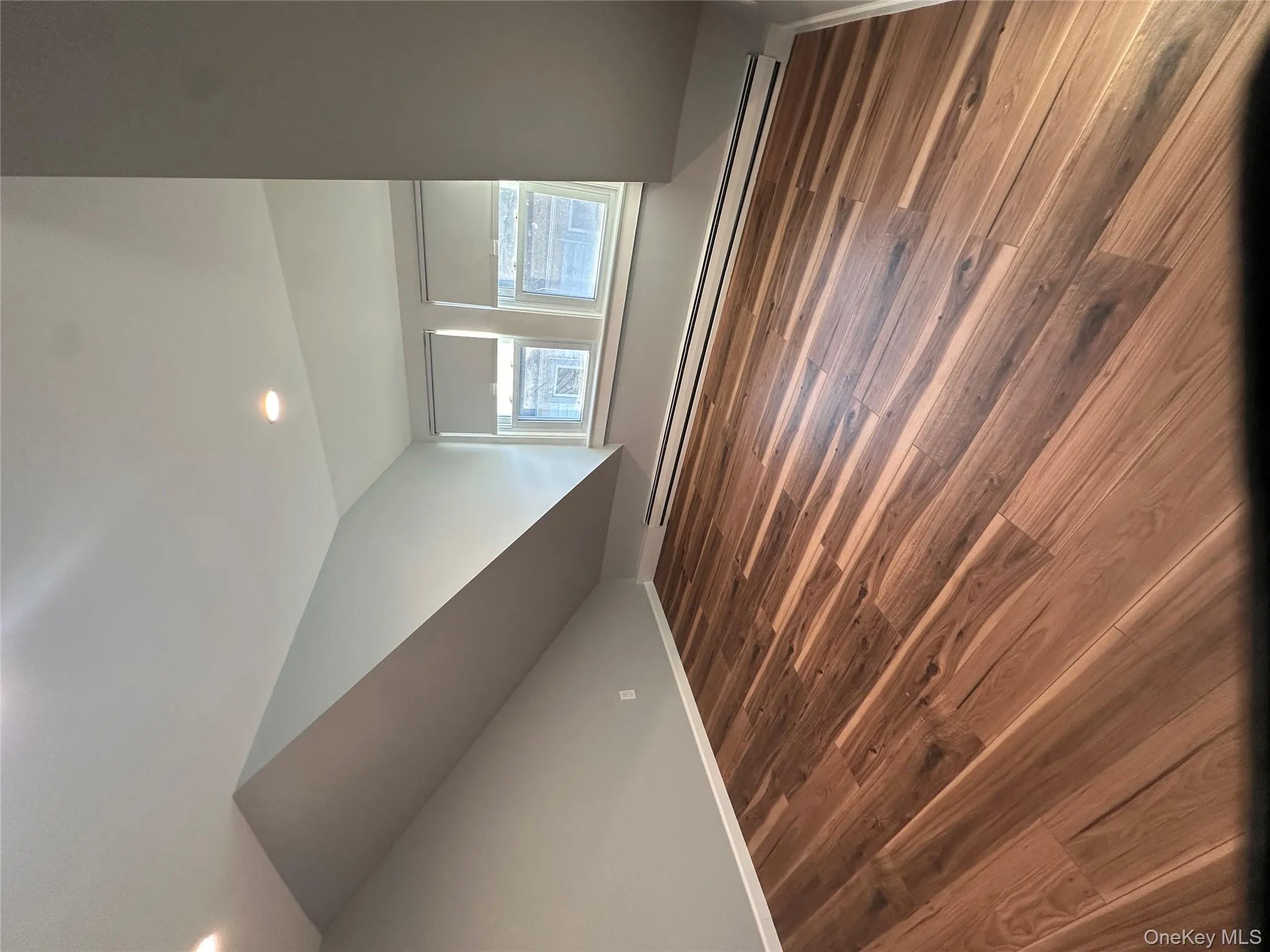 Additional living space with a baseboard heating unit, lofted ceiling, dark wood-style flooring, and recessed lighting Additional living space with a baseboard heating unit, lofted ceiling, dark wood-style flooring, and recessed lighting