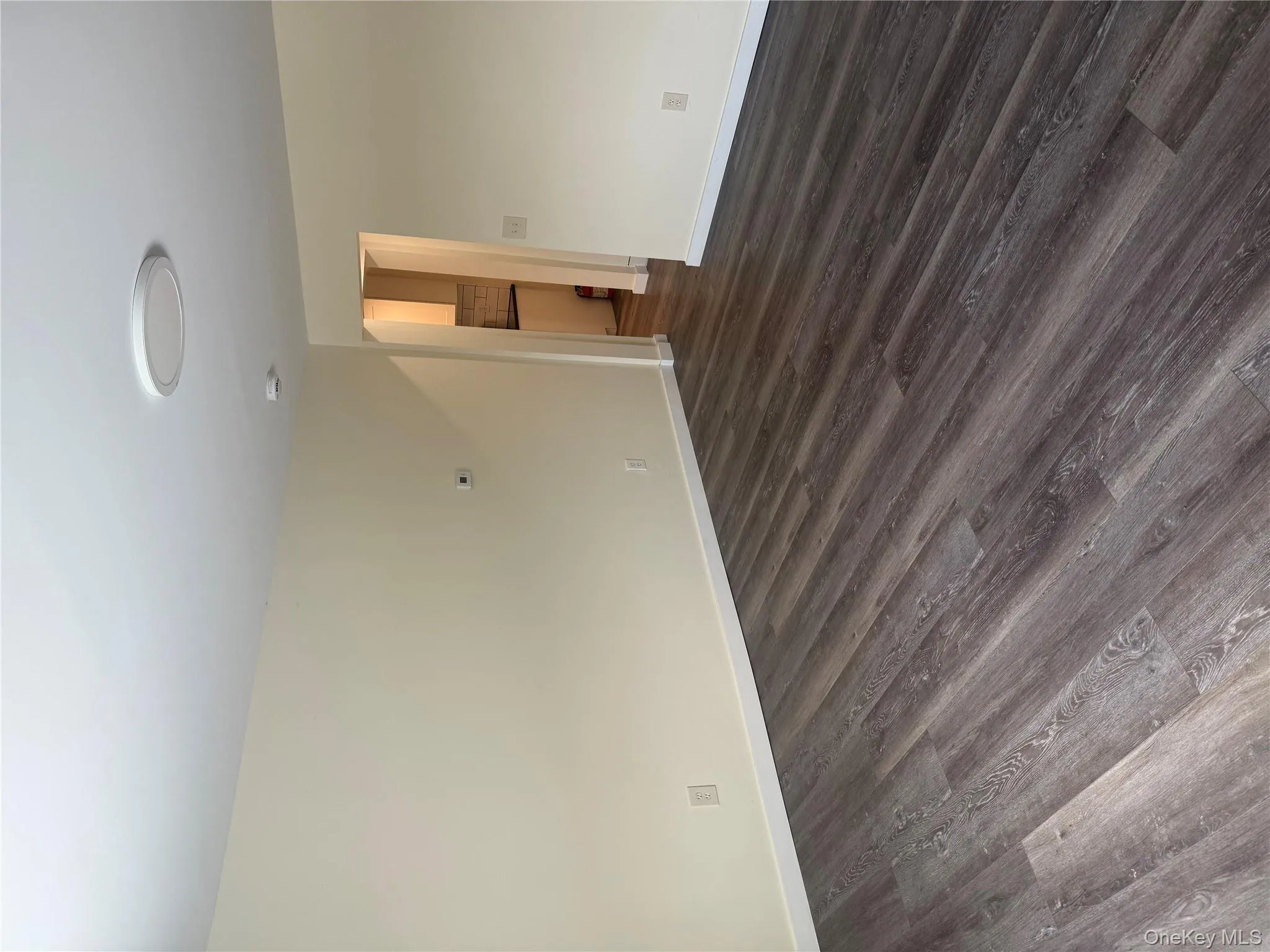 Empty room featuring dark wood-type flooring and baseboards Empty room featuring dark wood-type flooring and baseboards