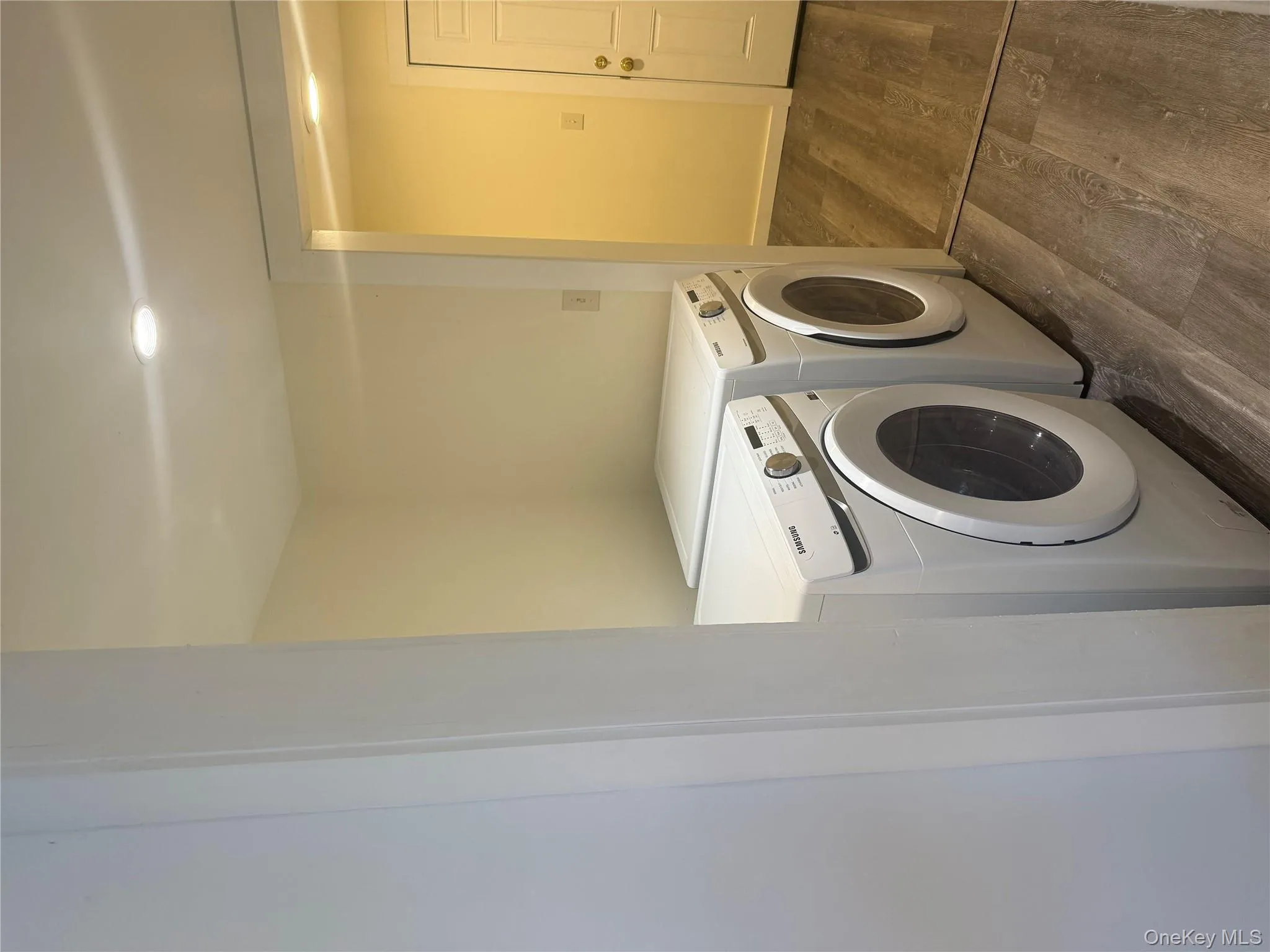 Washroom with dark wood-style flooring, separate washer and dryer, and recessed lighting Washroom with dark wood-style flooring, separate washer and dryer, and recessed lighting