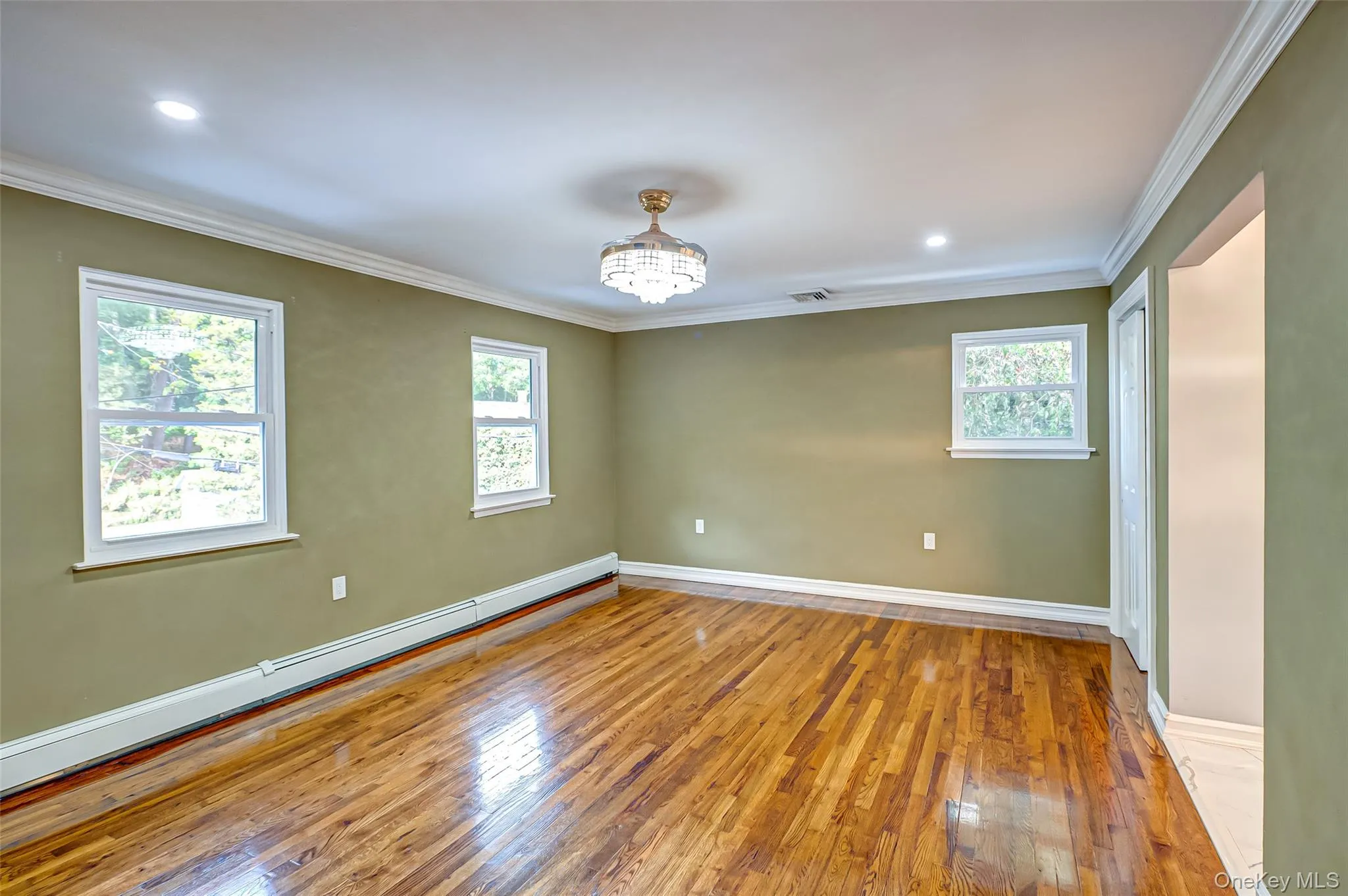 Primary bedroom wood flooring, walk in closet and additional closet, crown molding, plenty of natural light, and recessed lighting Primary bedroom wood flooring, walk in closet and additional closet, crown molding, plenty of natural light, and recessed lighting