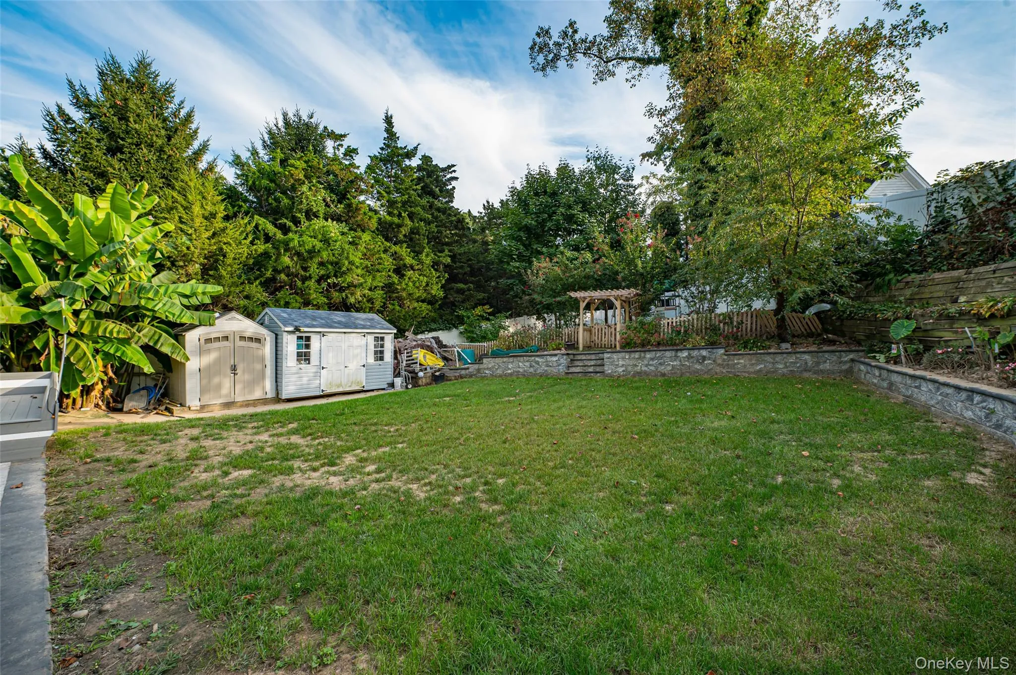 Fenced backyard featuring a storage unit, a playground. Fenced backyard featuring a storage unit, a playground.