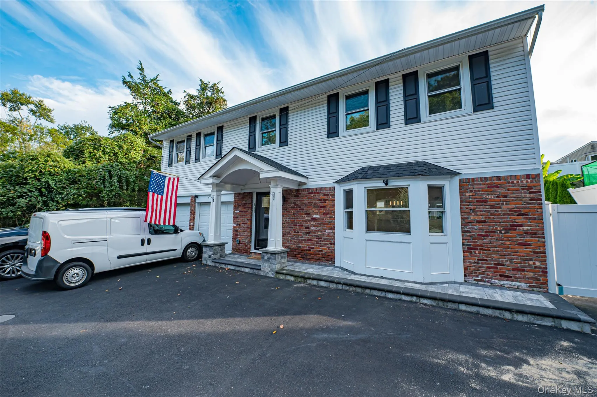 View of front of property with brick siding, a garage, and circular driveway View of front of property with brick siding, a garage, and circular driveway