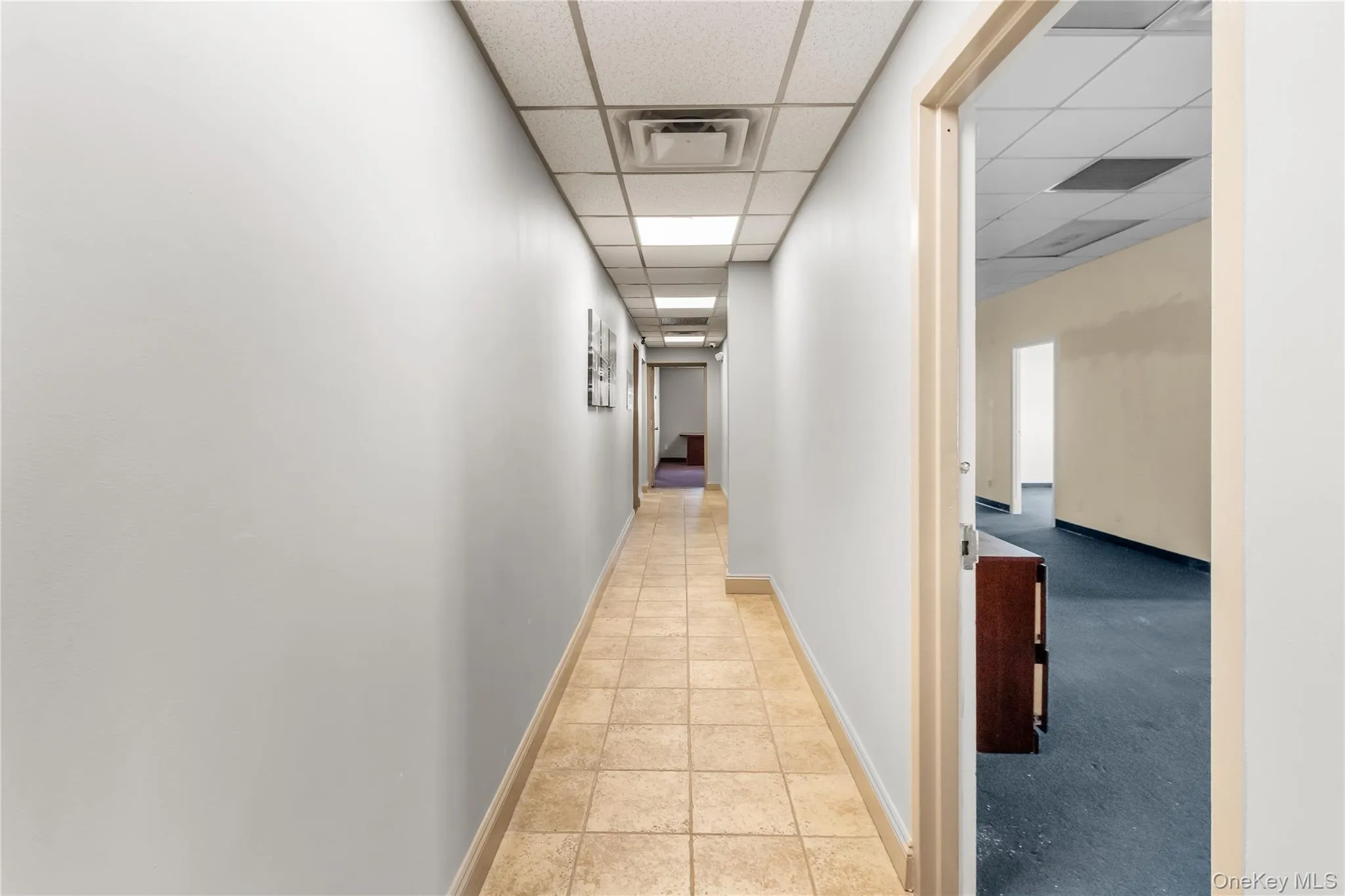 Hall with baseboards and light tile patterned floors Hall with baseboards and light tile patterned floors