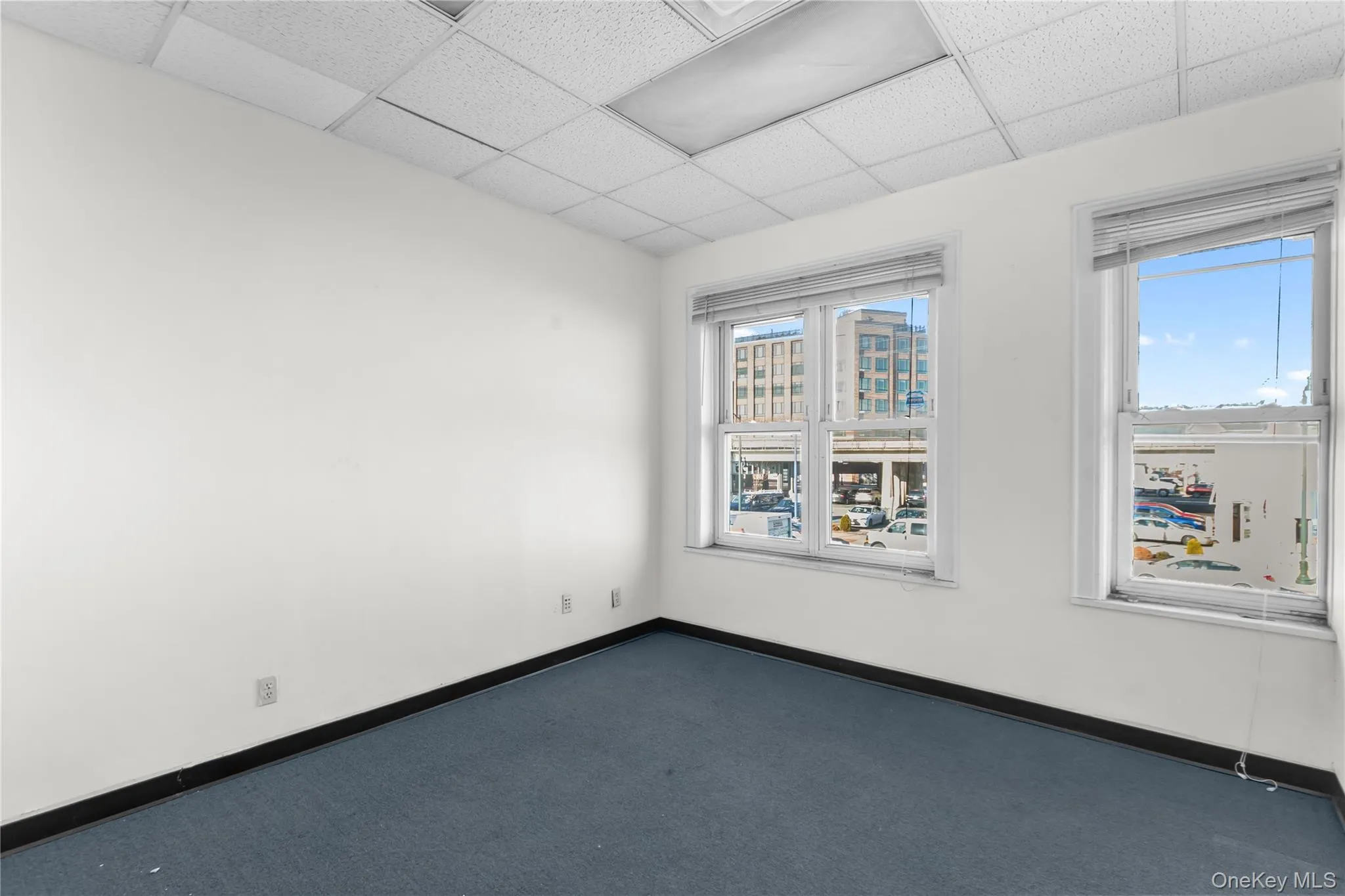 Unfurnished room with carpet and a drop ceiling Unfurnished room with carpet and a drop ceiling