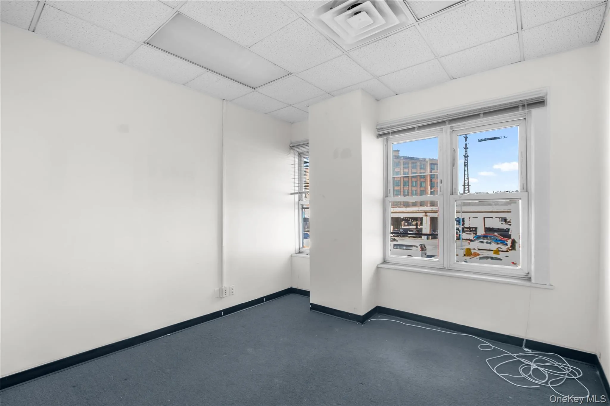 Spare room featuring baseboards and a drop ceiling Spare room featuring baseboards and a drop ceiling