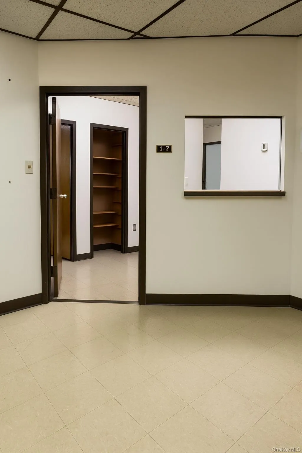 Spare room featuring a paneled ceiling and light tile patterned flooring Spare room featuring a paneled ceiling and light tile patterned flooring