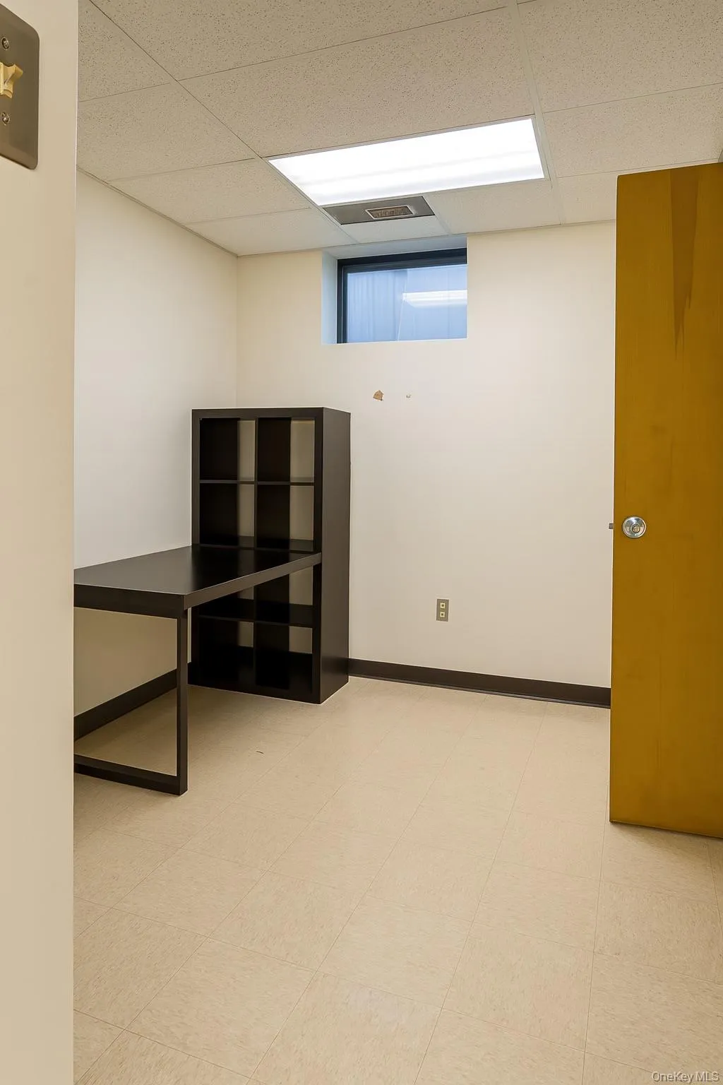 Basement with a drop ceiling and light floors Basement with a drop ceiling and light floors