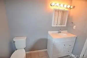 Half bathroom with vanity and light tile patterned floors Half bathroom with vanity and light tile patterned floors