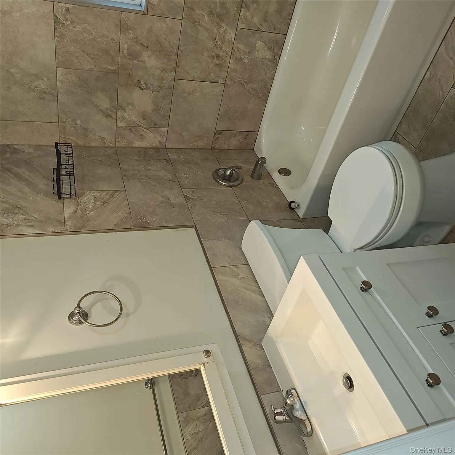 Full bathroom with vanity, shower / bath combination, tile patterned floors, and tile walls Full bathroom with vanity, shower / bath combination, tile patterned floors, and tile walls