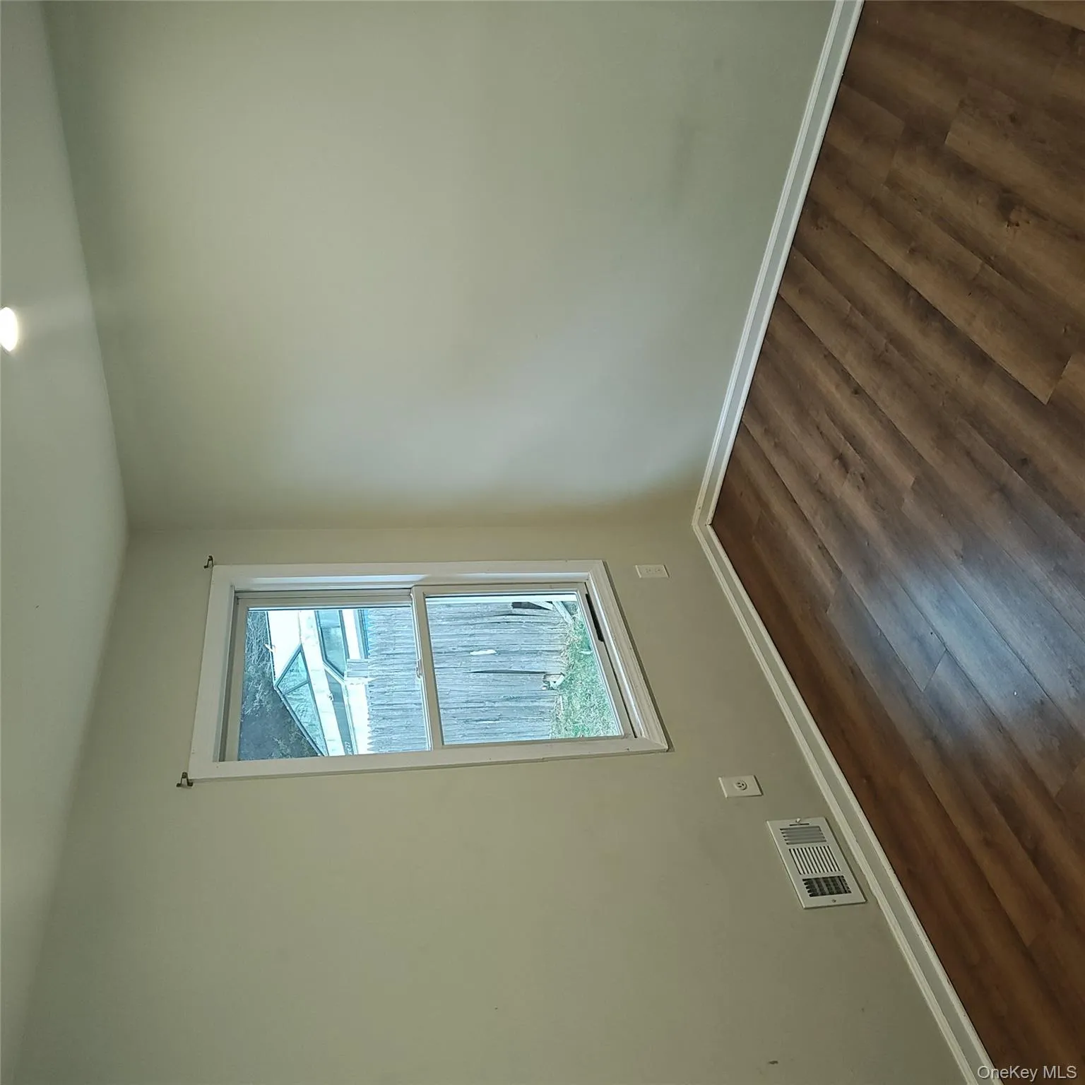 Spare room featuring baseboards and dark wood-style floors Spare room featuring baseboards and dark wood-style floors