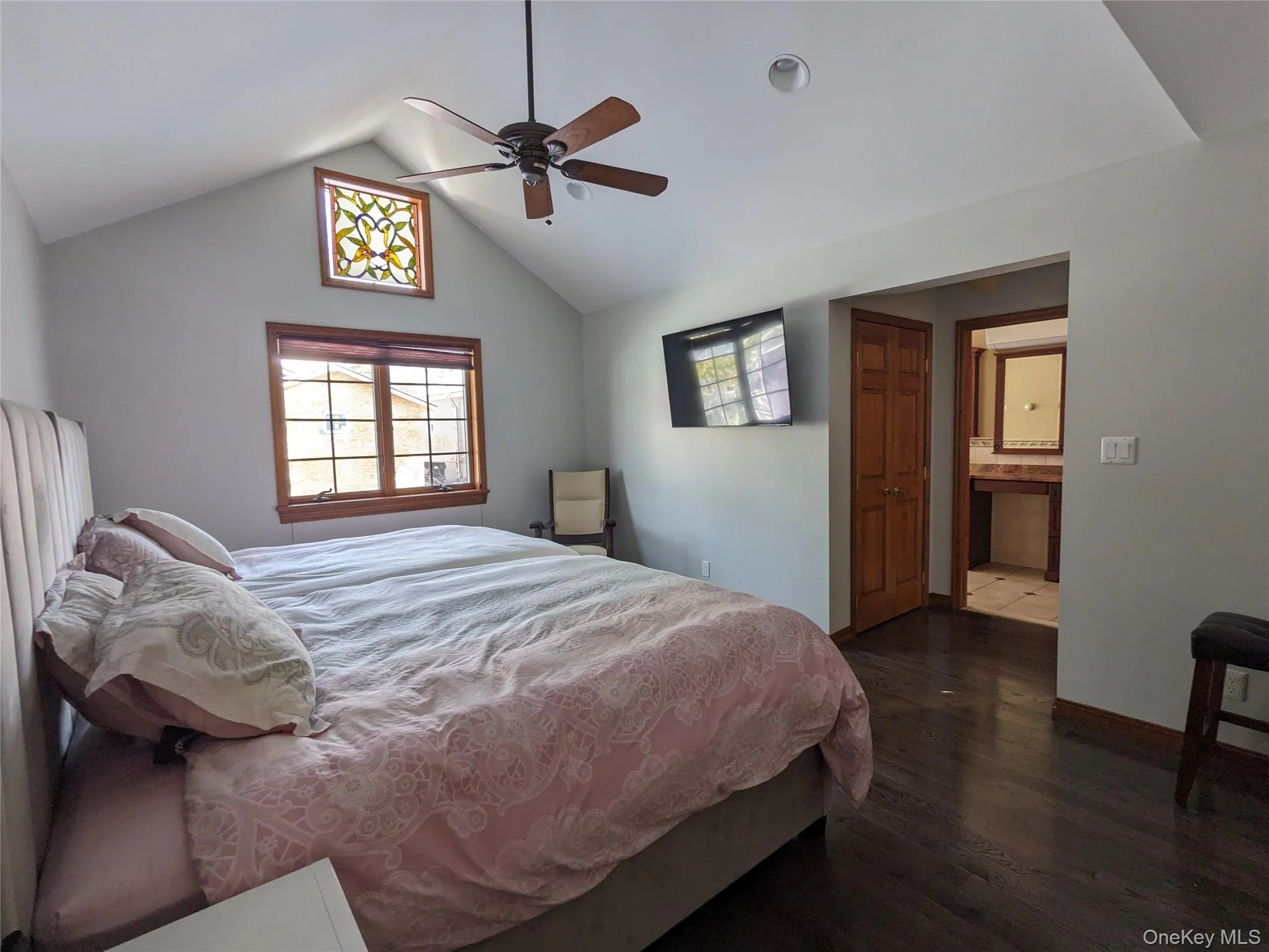 Bedroom featuring lofted ceiling, dark wood-style flooring, a ceiling fan, a closet, and connected bathroom Bedroom featuring lofted ceiling, dark wood-style flooring, a ceiling fan, a closet, and connected bathroom