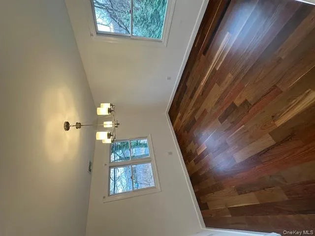 Unfurnished dining area with dark wood finished floors and a chandelier Unfurnished dining area with dark wood finished floors and a chandelier