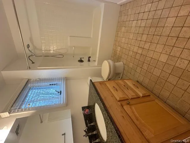 Bathroom featuring vanity, shower combination, and light tile patterned floors Bathroom featuring vanity, shower combination, and light tile patterned floors