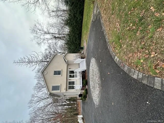 View of front of house featuring stucco siding, a deck, and driveway View of front of house featuring stucco siding, a deck, and driveway