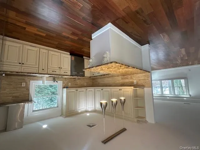 Kitchen with hanging light fixtures, light stone counters, exhaust hood, healthy amount of natural light, and recessed lighting Kitchen with hanging light fixtures, light stone counters, exhaust hood, healthy amount of natural light, and recessed lighting