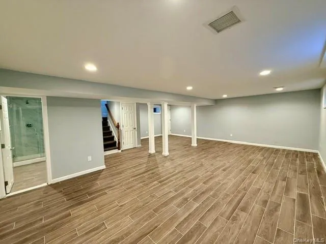 Finished basement with wood tiled floors, stairs, and recessed lighting Finished basement with wood tiled floors, stairs, and recessed lighting