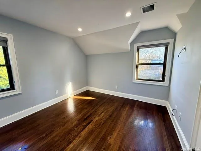 Additional living space with vaulted ceiling, dark wood-style flooring, and recessed lighting Additional living space with vaulted ceiling, dark wood-style flooring, and recessed lighting