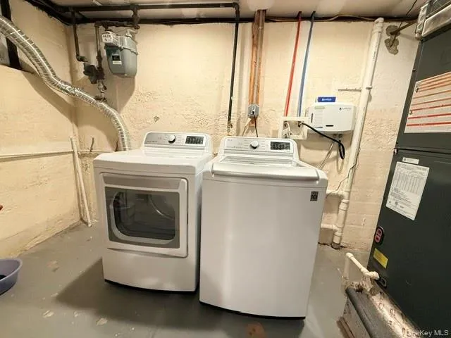 Laundry area with unfinished concrete flooring, heating unit, and independent washer and dryer Laundry area with unfinished concrete flooring, heating unit, and independent washer and dryer