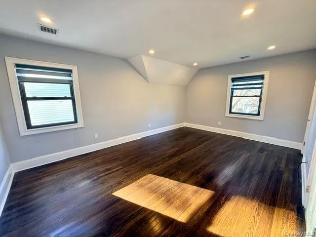Bonus room featuring dark wood-style flooring, vaulted ceiling, and recessed lighting Bonus room featuring dark wood-style flooring, vaulted ceiling, and recessed lighting