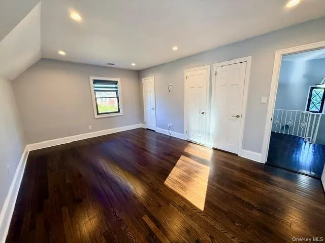 Unfurnished bedroom featuring dark wood-style floors, recessed lighting, and two closets Unfurnished bedroom featuring dark wood-style floors, recessed lighting, and two closets