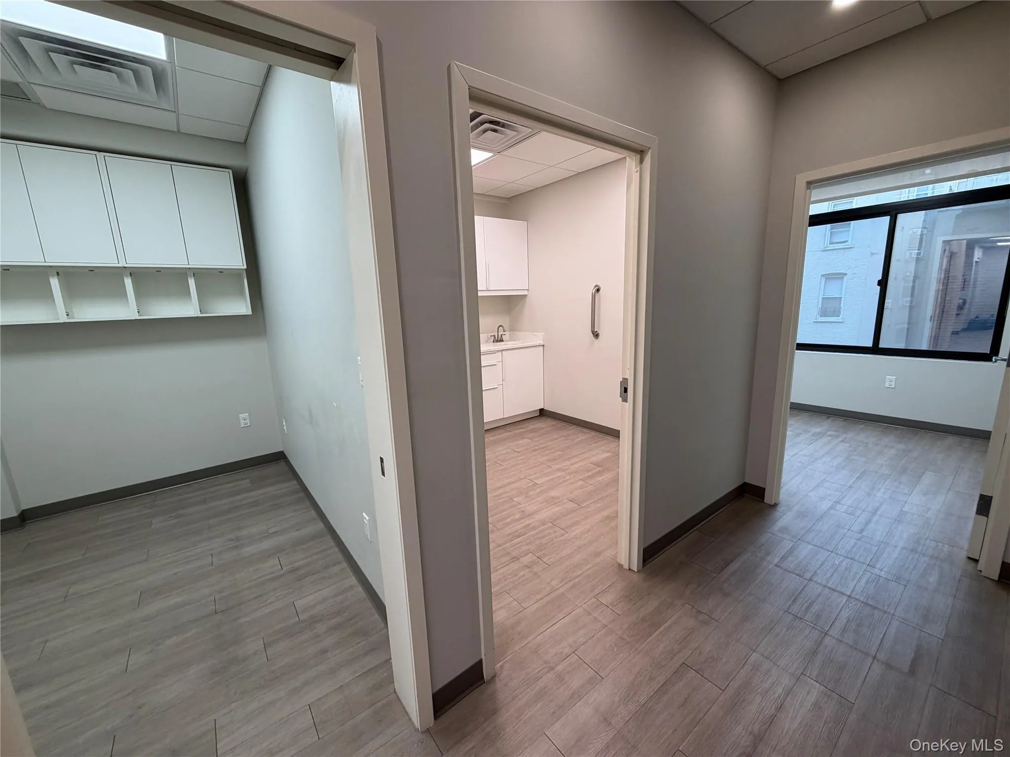 Hall with a paneled ceiling and light wood-style flooring Hall with a paneled ceiling and light wood-style flooring